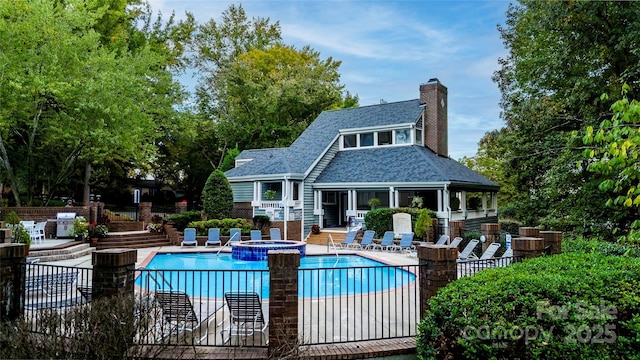 pool featuring a hot tub, a patio, and fence