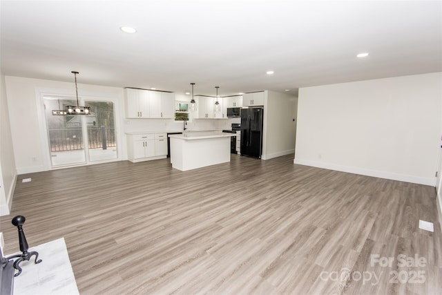 unfurnished living room featuring light hardwood / wood-style flooring and an inviting chandelier