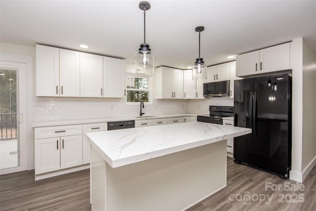 kitchen with black appliances, white cabinetry, sink, decorative light fixtures, and a kitchen island