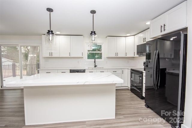 kitchen featuring black appliances, white cabinetry, a center island, and pendant lighting