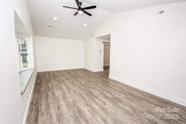 empty room with ceiling fan, light wood-type flooring, and lofted ceiling