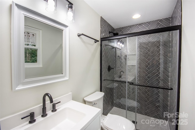 bathroom with a shower with door, toilet, and vanity