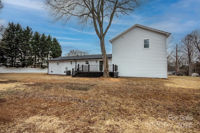 back of house with a wooden deck and a yard