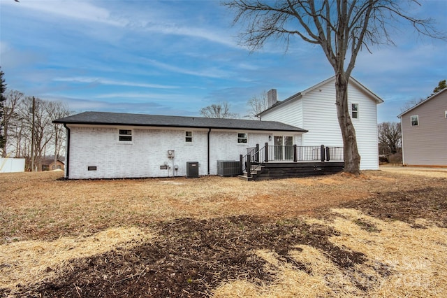 rear view of property featuring a deck, a yard, and central AC