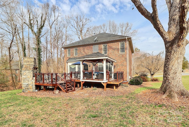 rear view of property with a wooden deck, a yard, and a gazebo