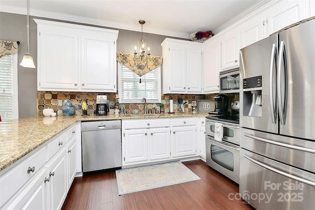 kitchen featuring appliances with stainless steel finishes, dark hardwood / wood-style floors, sink, white cabinets, and hanging light fixtures