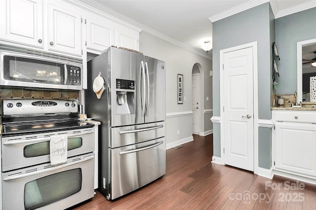 kitchen with ornamental molding, stainless steel appliances, and white cabinets