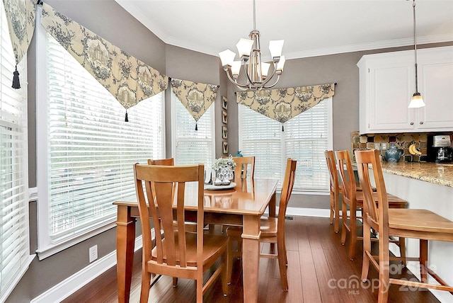 dining room with an inviting chandelier, crown molding, and dark hardwood / wood-style floors