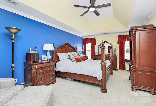 carpeted bedroom with a tray ceiling, ornamental molding, and ceiling fan