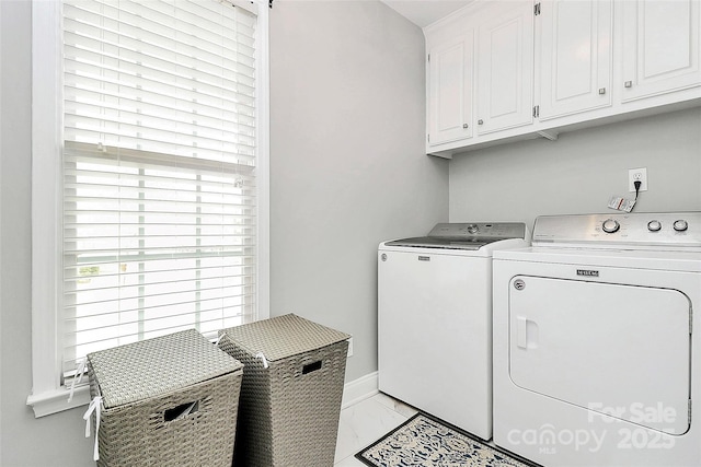 laundry area with washer and clothes dryer and cabinets