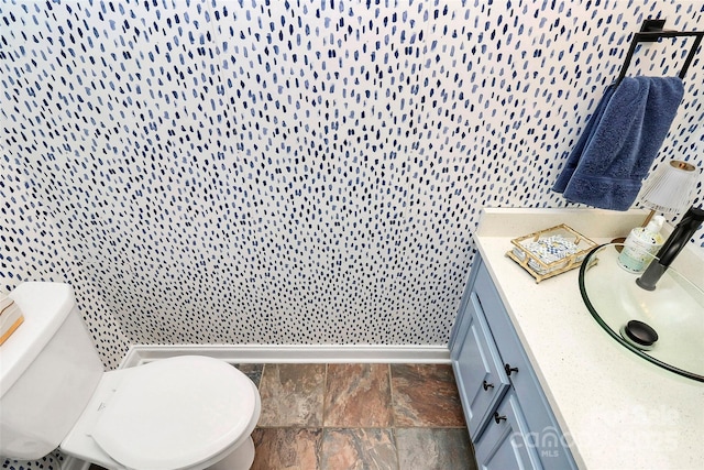 bathroom featuring vanity, toilet, and tile walls