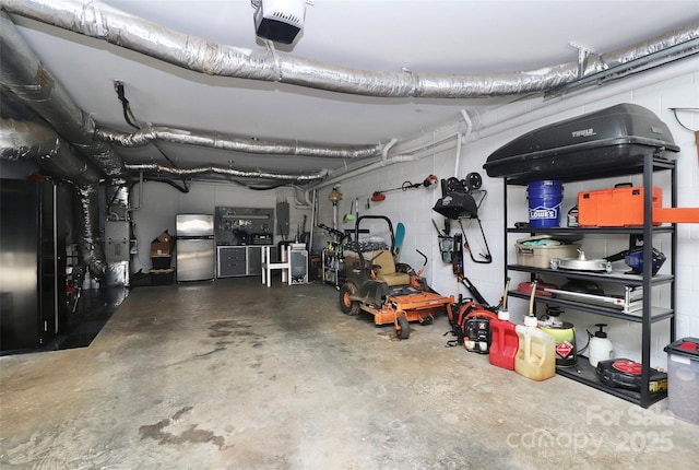 garage with a garage door opener and stainless steel refrigerator