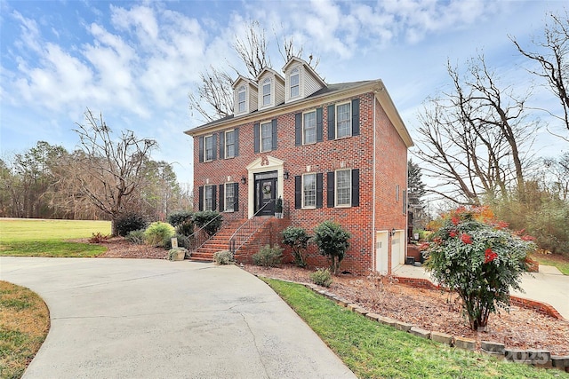 colonial house featuring a garage and a front yard