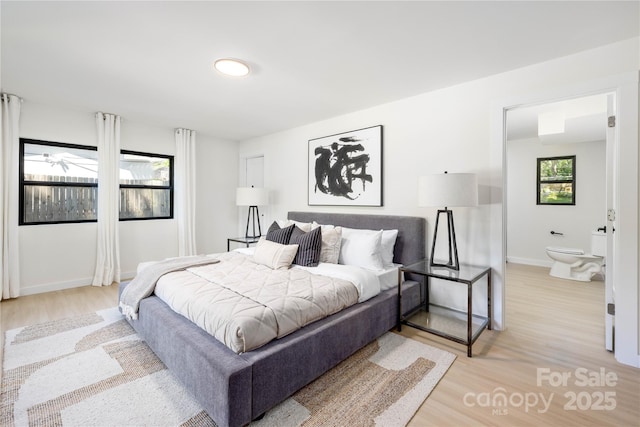 bedroom featuring light hardwood / wood-style floors and ensuite bath