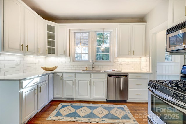 kitchen with white cabinets, appliances with stainless steel finishes, sink, and dark hardwood / wood-style flooring