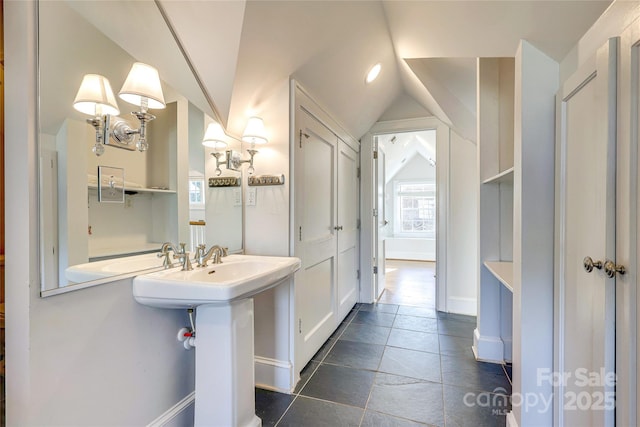 bathroom featuring vaulted ceiling and sink