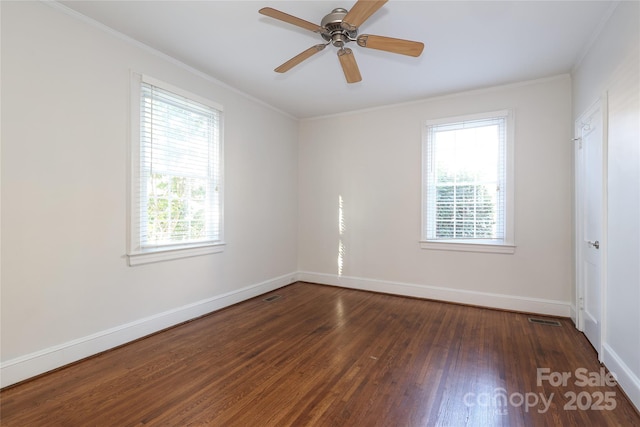 empty room with ceiling fan, dark hardwood / wood-style flooring, ornamental molding, and a healthy amount of sunlight