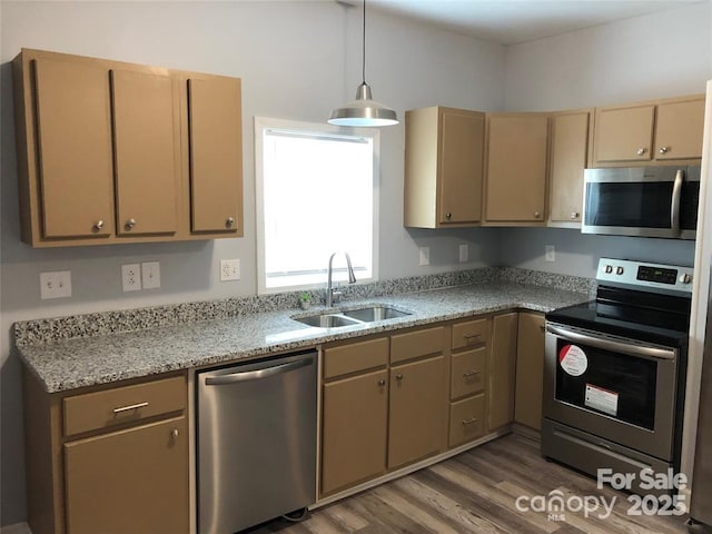 kitchen with pendant lighting, sink, hardwood / wood-style flooring, appliances with stainless steel finishes, and light brown cabinets