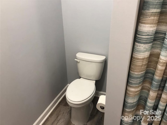 bathroom with toilet and wood-type flooring