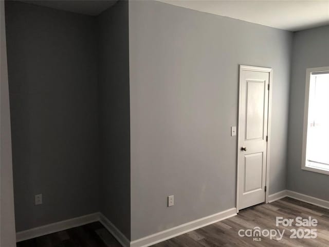 empty room with dark wood-type flooring