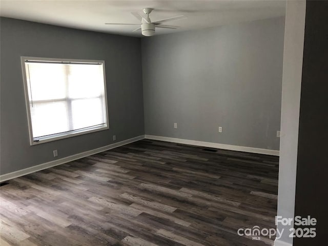 spare room with ceiling fan and dark wood-type flooring