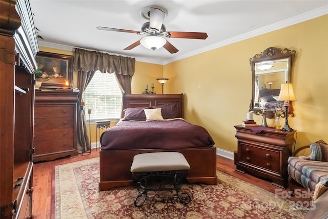 bedroom with ceiling fan, hardwood / wood-style flooring, and crown molding