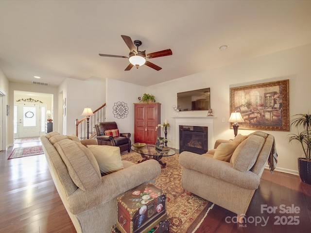 living room with dark wood-type flooring and ceiling fan