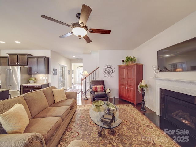 living room featuring dark hardwood / wood-style flooring and ceiling fan