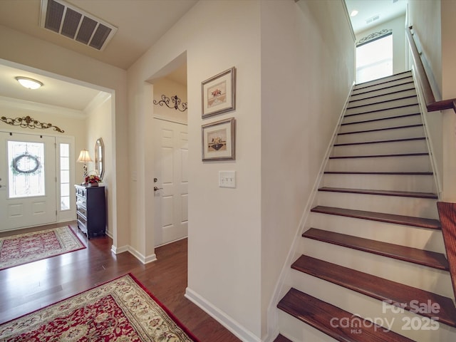 foyer featuring ornamental molding and dark hardwood / wood-style floors