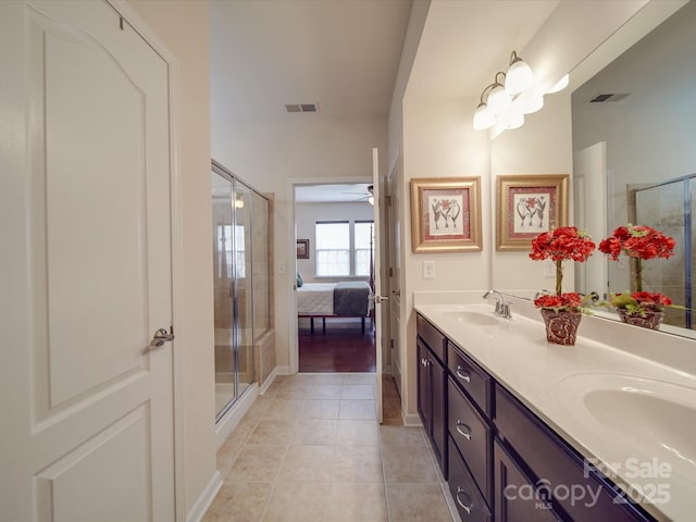 bathroom with walk in shower, vanity, and tile patterned flooring