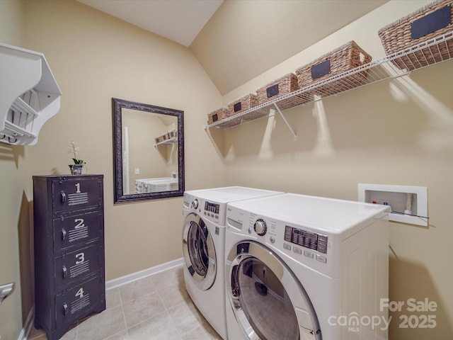 clothes washing area featuring light tile patterned floors and washer and clothes dryer