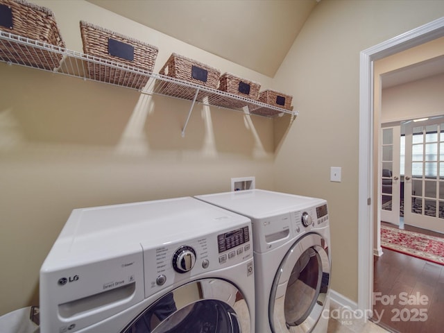 laundry area with hardwood / wood-style flooring, washing machine and dryer, and french doors