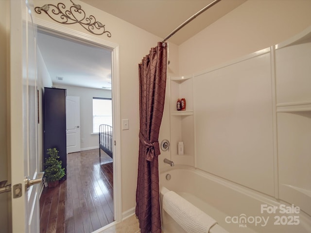 bathroom featuring hardwood / wood-style floors and shower / bath combo with shower curtain