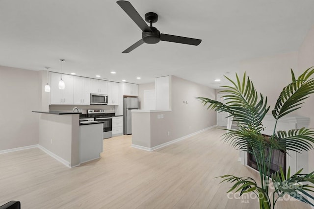 kitchen with ceiling fan, white cabinetry, hanging light fixtures, kitchen peninsula, and stainless steel appliances