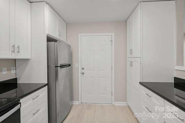 kitchen featuring white cabinetry, light hardwood / wood-style flooring, black range with electric stovetop, and stainless steel refrigerator