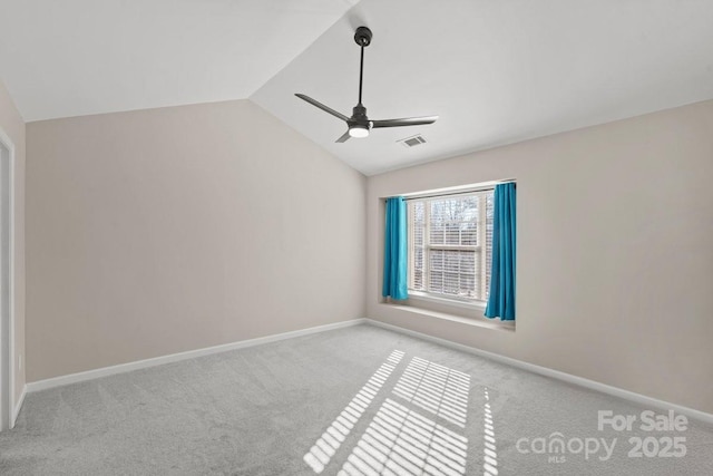 carpeted empty room featuring vaulted ceiling and ceiling fan