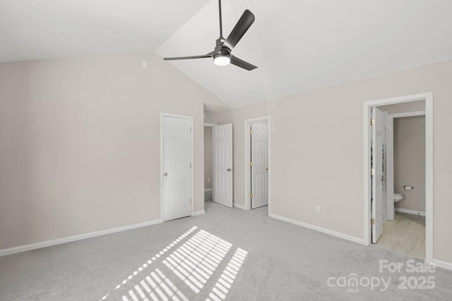 unfurnished bedroom with ceiling fan, connected bathroom, light carpet, and lofted ceiling