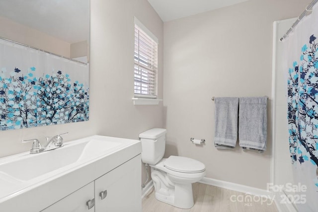 bathroom with wood-type flooring, toilet, and vanity