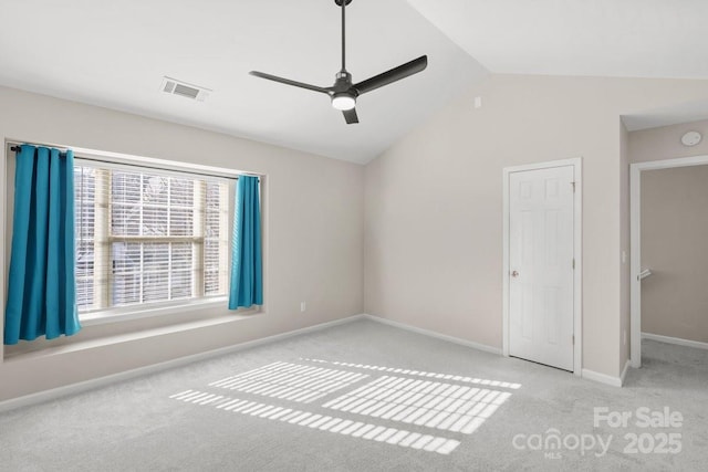 carpeted spare room with ceiling fan and vaulted ceiling