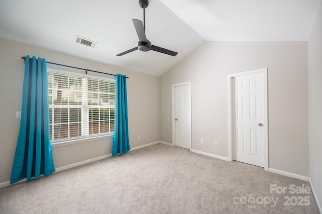 unfurnished bedroom featuring ceiling fan, vaulted ceiling, and light carpet