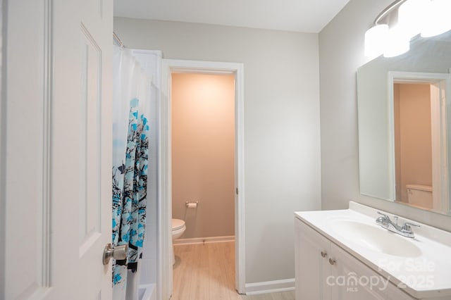 bathroom with vanity, toilet, hardwood / wood-style floors, and a shower with curtain