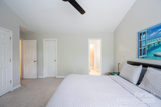 carpeted bedroom featuring ceiling fan, ensuite bathroom, and vaulted ceiling