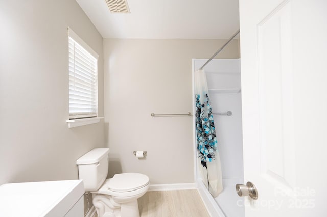 bathroom with wood-type flooring, toilet, walk in shower, and vanity