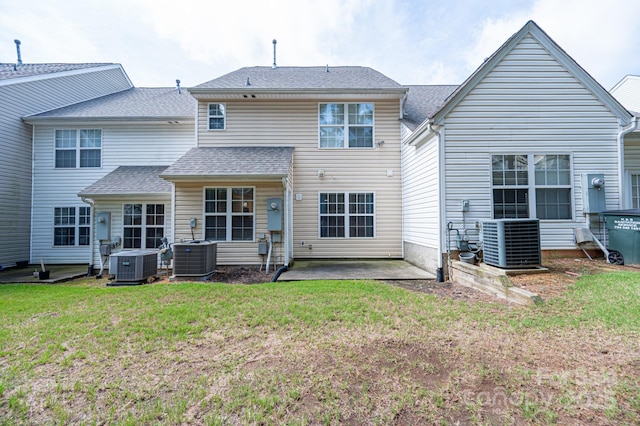 back of property with cooling unit, a patio area, and a yard