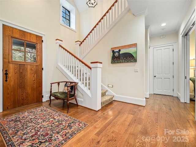 entrance foyer featuring crown molding and light hardwood / wood-style flooring