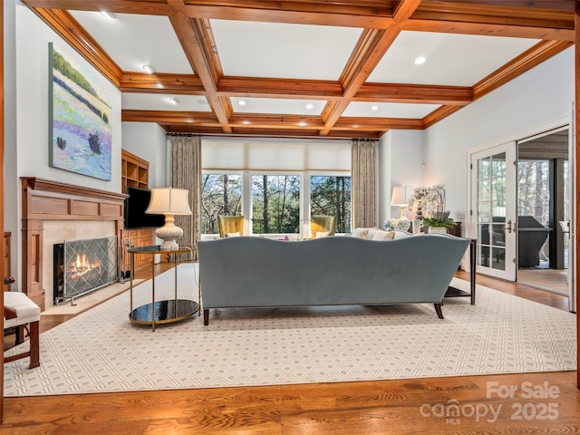 living room with beamed ceiling, crown molding, coffered ceiling, and hardwood / wood-style floors