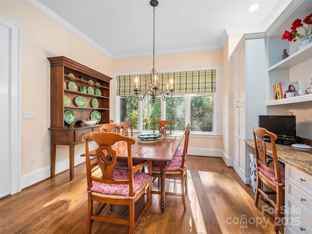 dining room with crown molding, a chandelier, and hardwood / wood-style flooring