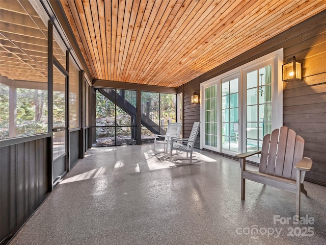 unfurnished sunroom featuring wood ceiling and plenty of natural light