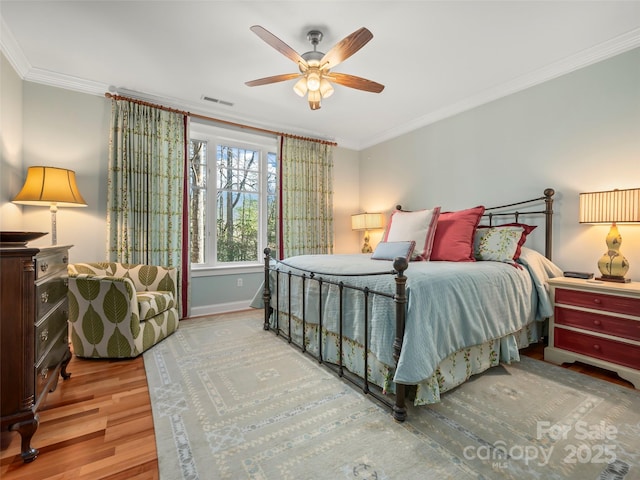 bedroom featuring ceiling fan, crown molding, and light hardwood / wood-style floors