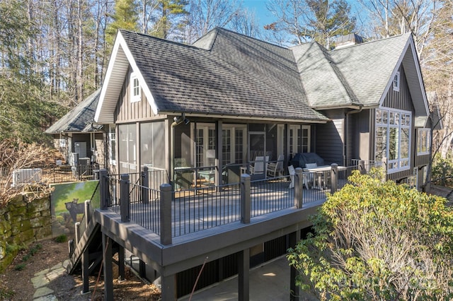 back of property featuring a deck and a sunroom